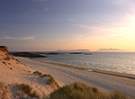 Sands of Morar and sun setting over distant Inner Hebridean Isles